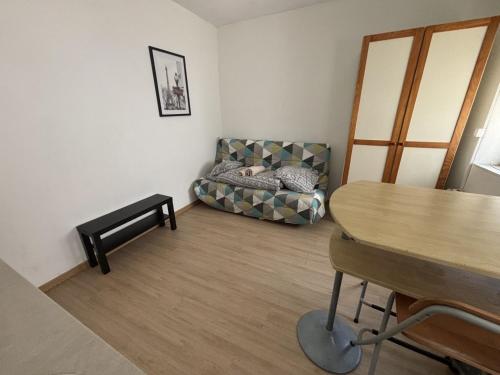 a living room with a couch and a table at Le Saint Vaast - Studio au centre d'Arras in Arras