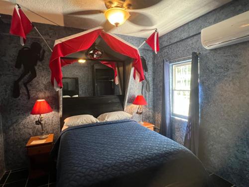 a bedroom with a blue bed with a red canopy at Belize Budget Suites in San Pedro