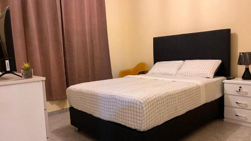 a bedroom with a bed with a black headboard at Casa Shelter in Chimbote