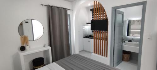 a white bathroom with a sink and a mirror at Saris rooms in Pera Gyalos