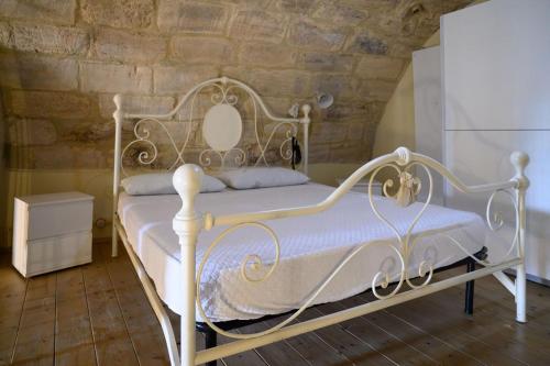 a white bed in a room with a stone wall at Loft in cisterna romana in Amelia