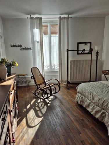 a bedroom with a bed and a chair in it at Les Gites du 74 R Le Classique in Senones