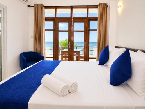 a bedroom with a large bed with a view of the ocean at Dutch Bay Villa - Trincomalee in Trincomalee