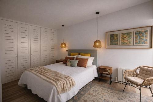 a bedroom with a bed and a chair at Entre Patios 1BR Costa Nova Beach in Gafanha da Encarnação