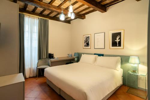 a bedroom with a bed and a desk and a window at Maison Ventiquattro in Talamello