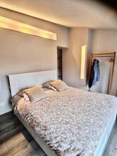 a bedroom with a large white bed with two pillows at Le refuge médiéval - Appartement climatisé perché sous les toits de Billom in Billom