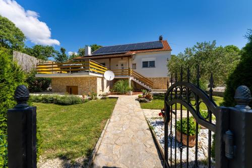 a gate to a house with a solar roof at My Dalmatia - Villa Manda Adriatic with Private Heated Pool in Skradin