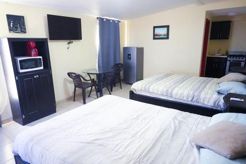 a hotel room with two beds and a table with chairs at Rancho Percebu Beach Studio 5 in San Felipe