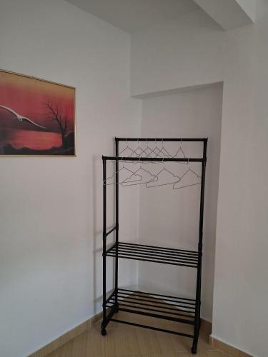 a shelf in a room next to a painting at Seren Apartment in Vlorë