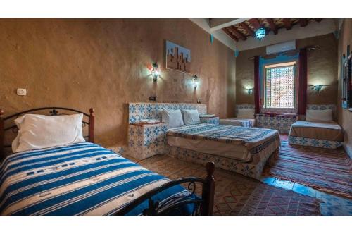 a bedroom with two beds and a couch at Maison Zouala in Zouala