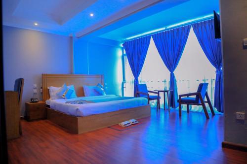 a blue bedroom with a bed and a table and chairs at Burqito International Hotel in Āwasa