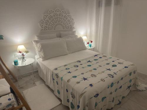 a bedroom with a large bed with a white comforter at Le Jardin Secret in Le Vauclin