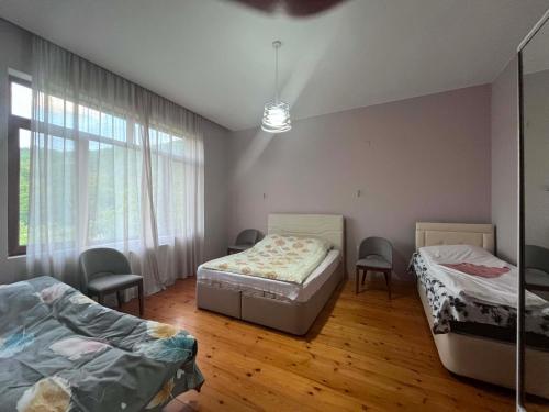 a room with two beds and two chairs in it at Likhauri Guesthouse in Likhauri