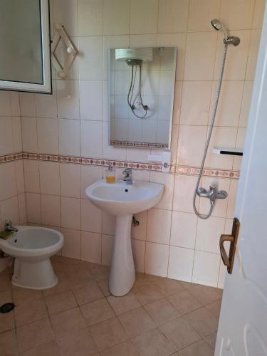 a bathroom with a sink and a toilet and a mirror at Seren Apartment in Vlorë
