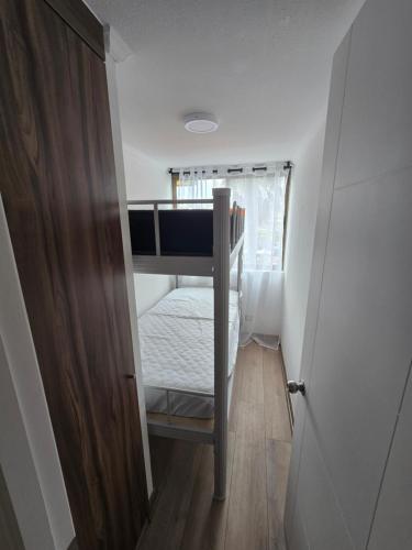 a small room with a bunk bed and a door at Baquedano in Coquimbo