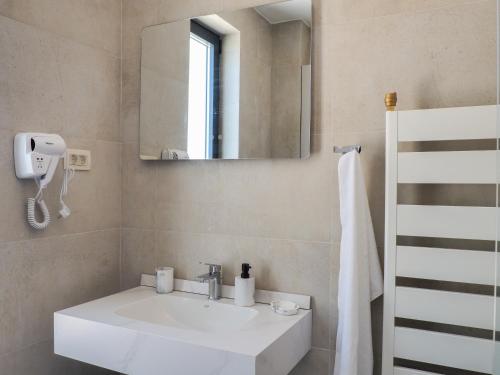 a bathroom with a white sink and a mirror at Elysium Villa in Kaluđerac