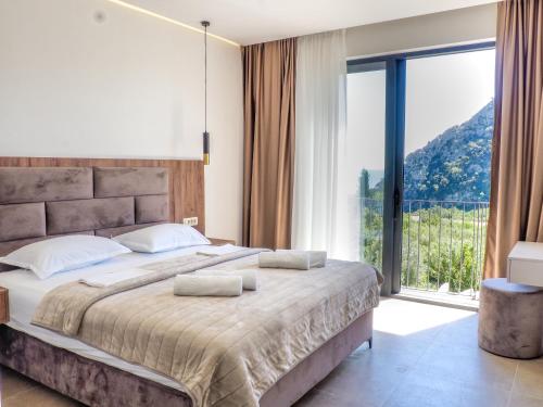a bedroom with a large bed with a large window at Elysium Villa in Kaluđerac