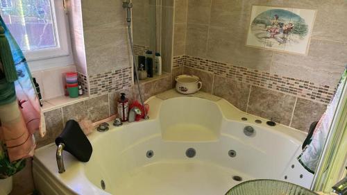 a large white tub in a bathroom with a window at Bonnye's guest house in Ramsgate