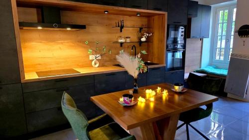 a kitchen with a wooden table and a wooden counter top at Ecrin d'exception avec jacuzzi et salon cinéma in Penne-dʼAgenais