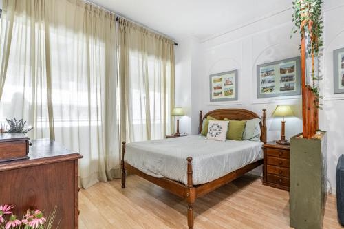 a bedroom with a bed and a large window at Bom Braga AL in Braga