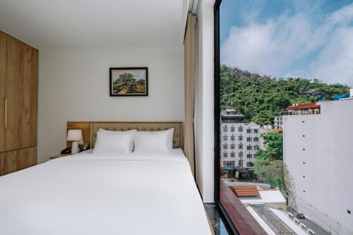 a bedroom with a bed and a large window at Catba Vista Hotel - New 2026 - Infinity Pool in Cat Ba