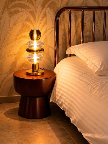a lamp on a table next to a bed at Superbe Appartement - Centre Calvi - Parking privé in Calvi