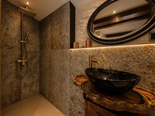 a bathroom with a black sink and a mirror at Le Lovy , Studio indépendant avec Jacuzzi in Cézac