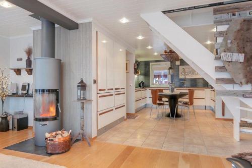 a living room with a fireplace and a table and a staircase at RIBO Apartment Katterjåkk in Riksgränsen