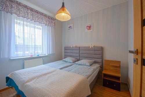 a bedroom with a bed and a large window at Apartament u Jadwigi in Jantar