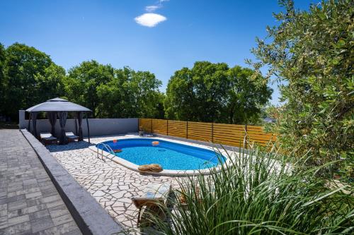 a swimming pool in a yard with an umbrella at My Dalmatia - Villa Manda Adriatic with Private Heated Pool in Skradin
