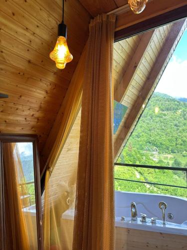 a bathroom with a window with a tub and a sink at cottage sunrise house merisi in Merisi