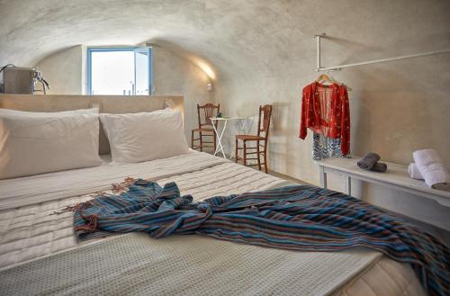 a bed with a blanket on it in a room at 318 Oia Villa in Oia
