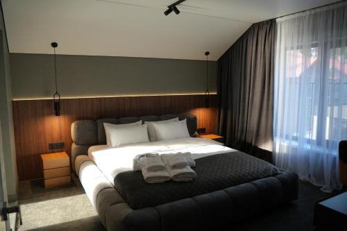 a bedroom with a large bed with two towels on it at Gloria Hotel in Szack