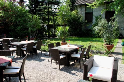 a patio with tables and chairs in a yard at Hotel Simonshof in Wolfsburg