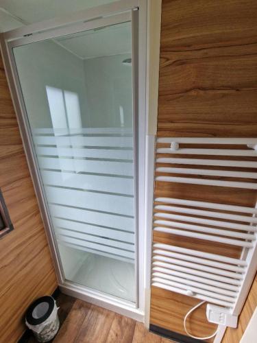 a sliding glass door in a room with wooden floors at Camping Paus'Art Déco in Villemer