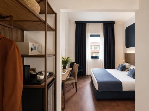 a hotel room with a bed and a desk and a bed and a table at Grand Hotel Tiberio in Rome