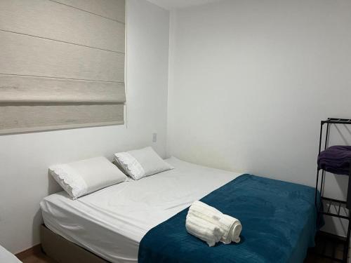 a white bed with two towels on it in a room at 7 min de Cabo Frio AP LISBOA in São Pedro da Aldeia