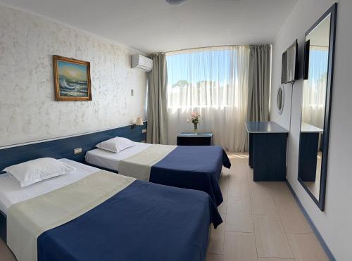 a hotel room with two beds and a window at Hotel Venus in Venus