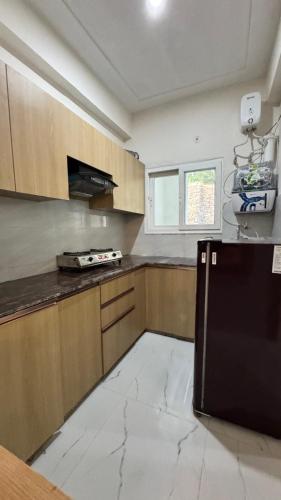 a large kitchen with a black refrigerator in it at Healer home in Rishīkesh