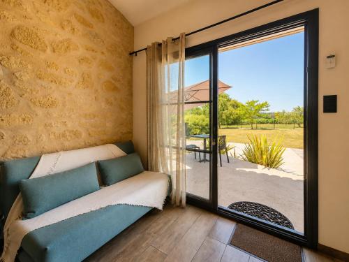 a room with a couch and a sliding glass door at L inarretable studio independant in Cézac