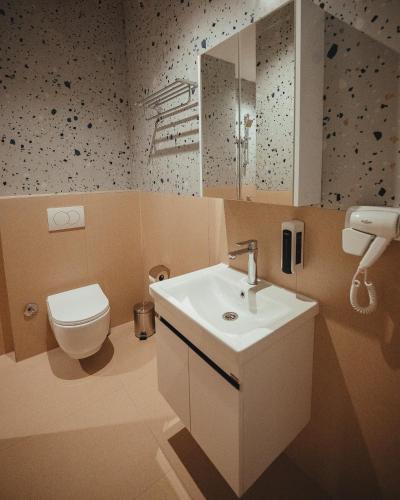ein Badezimmer mit einem weißen Waschbecken und einer Toilette in der Unterkunft Noir Hotel in Gjakove