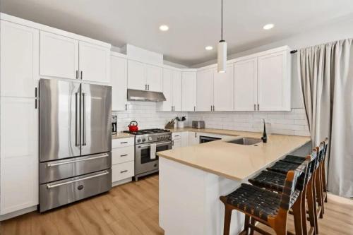 a kitchen with white cabinets and a stainless steel refrigerator at Cozy Luxury in Big Sky in Big Sky