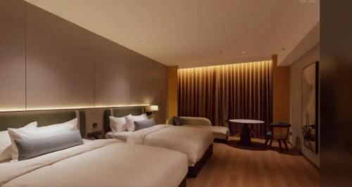 a hotel room with two beds and a table at VOS Suites By BOLD in Gelugor