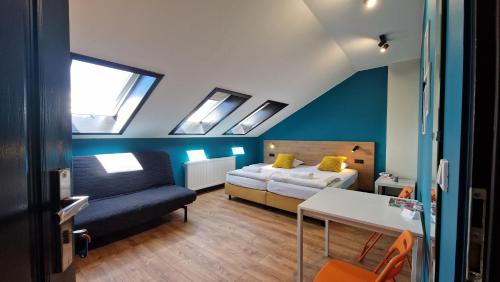 a bedroom with a bed and a couch and skylights at Hello Bielsko Biała in Bielsko-Biała