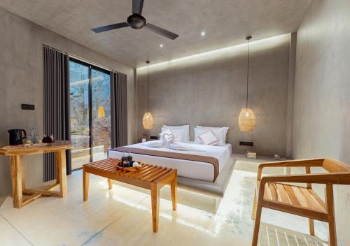 a bedroom with a white bed and a table at Cavendish Polhena in Matara