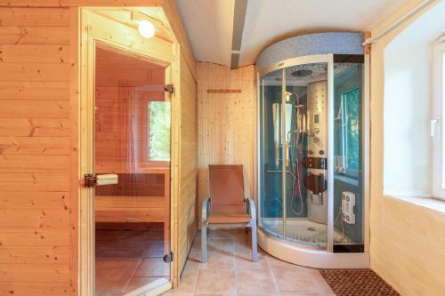 a bathroom with a shower with a chair in it at Alte Wassermuehle Hollebek in Bredstedt