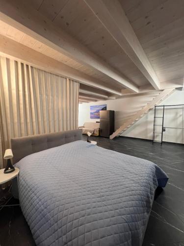 a bedroom with a large bed and a staircase at Casa Gloria in Zelbio