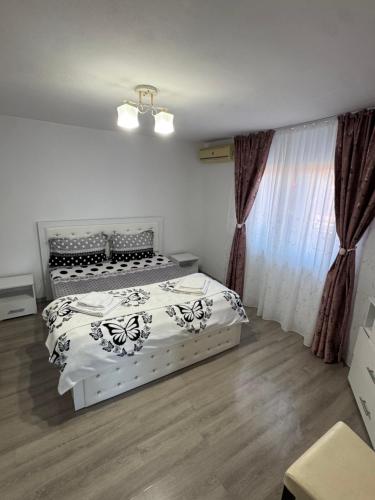 two beds in a bedroom with curtains and wood floors at Casa Denisa in Sulina
