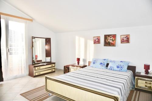 ein weißes Schlafzimmer mit Bett und Spiegel in der Unterkunft Rosette suites Trogir Seget Vranjica in Seget Vranjica