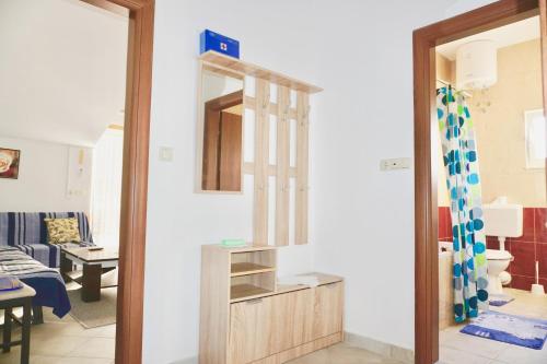 ein Wohnzimmer mit einem Spiegel und einem Surfbrett in der Unterkunft Rosette suites Trogir Seget Vranjica in Seget Vranjica